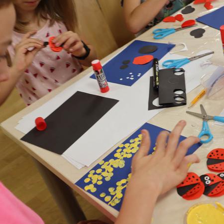 Dzieci malują kropki farbami i przyklejają klejem czerwone koła