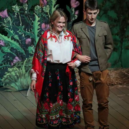 Dziewczyna w stroju góralski oraz mężczyzna w trakcie spektaklu.