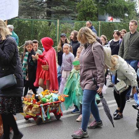 Grupa rodziców z dziećmi maszerująca pod przedszkolem