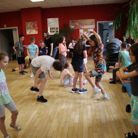 Grupa dzieci tańczy wykonując rożne figury taneczne