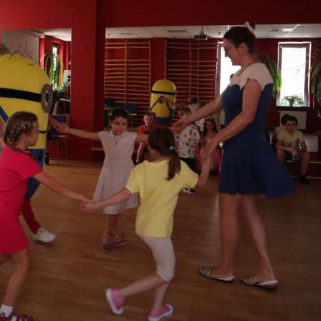Dzieci razem z Panią psycholog tańczą w kole 