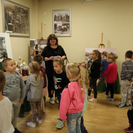 Grupa dzieci wraz z nauczycielką ogladają wystawę lalek artystycznych