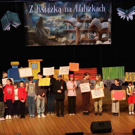 Grupa dzieci z banerami a scenie 