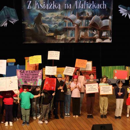 Grupa dzieci z banerami a scenie w przebraniach