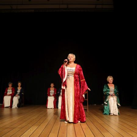 Kobieta w czerwonej sukience występuje na scenie