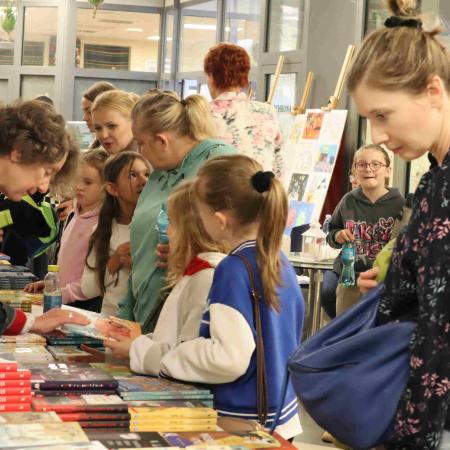 Grupa ludzi oglądających książki
