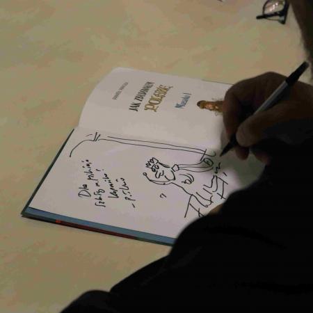 Autor książki pisze autograf