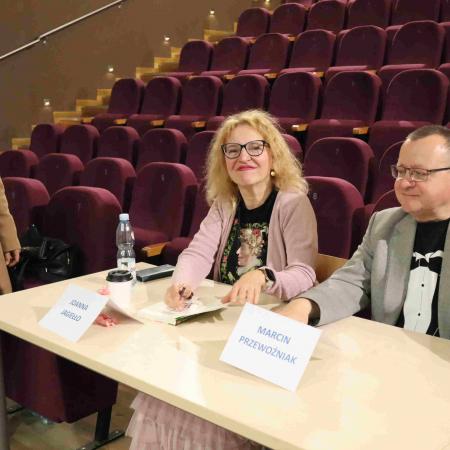 Dwóch autorów książek siedzących przy sole