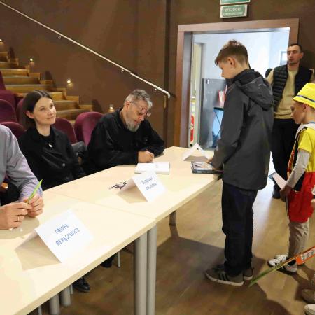 Autor książki daje autograf chłopcu 