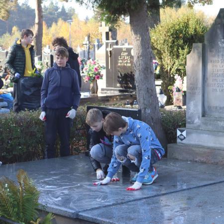 Chłopcy sprzątający zabytkowe groby