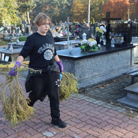 Chłopak ze SP w Drzewicy podczas sprzątania zabytkowych grobów na cmentarzu w Drzewicy 