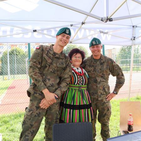 Kobieta w stroju ludowym z dwoma żołnierzami