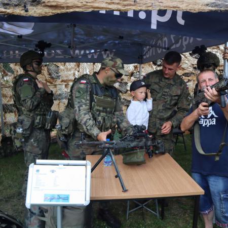 Chłopiec ogląda broń pokazywaną przez żołnierzy