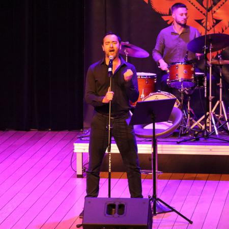 Mariusz Ostrowski śpiewa przy mikrofonie na scenie w RCK