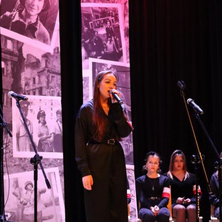 Dziewczyna śpiewa przy mikrofonie na scenie w RCK