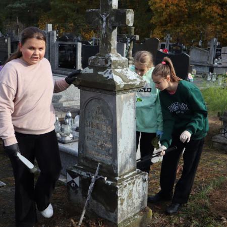 Dziewczynki porządkują zabytki na cmentarzu w Drzewicy