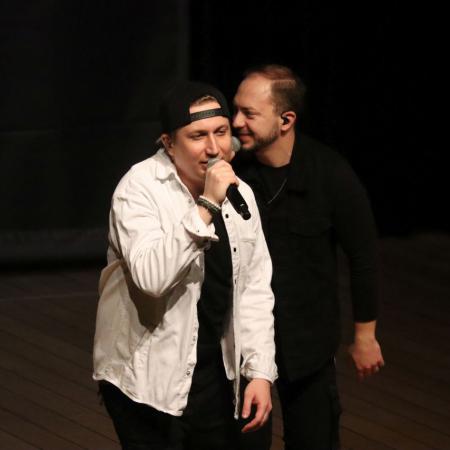 Dwóch mężczyzn śpiewa do mikrofonu