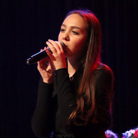 Dziewczyna śpiewa do mikrofonu na scenie 