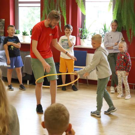 Instruktor Szymon bawi się z dziećmi na zajęciach wakacyjnych w rck