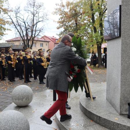 Przedstawiciele grup społecznych składają kwiaty pod pomnikiem.