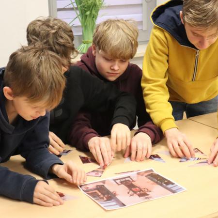 Grupa chłopców układa puzzle na warsztatach ze "Sztuki okopowej"