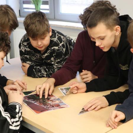 Grupa chłopców układa puzzle na warsztatach