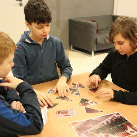 Chłopcy z SP w Drzewicy układają puzzle na warsztatach do wystawy "Sztuka Okopowa"