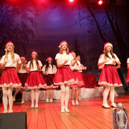 Dziewczyny w czerwonych spódnicach tańczą na scenie 
