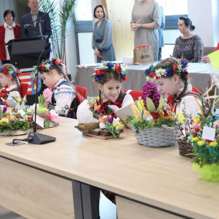 Dzieci w strojach ludowych siedzą przy stole w Starostwie Powiatowym w Opocznie podczas finału konkursu na plastykę zdobniczo-obrzędową