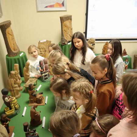 Dzieci oglądają drewniane figurki 