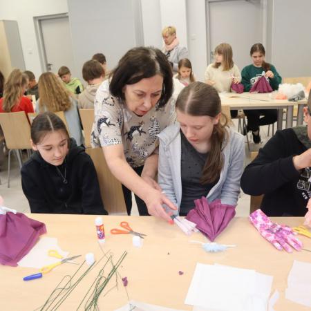 Pani Anna Michalczyk pomaga dziewczynom w robieniu lalek