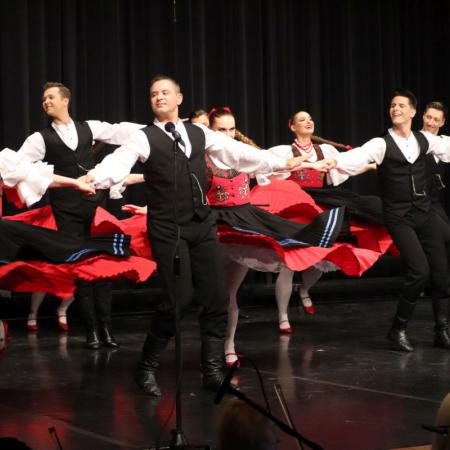 Kobiety i mężczyźni z zespołu "Śląsk" tańczą na scenie 