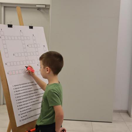Chłopiec wpisuje hasło na krzyżówce 