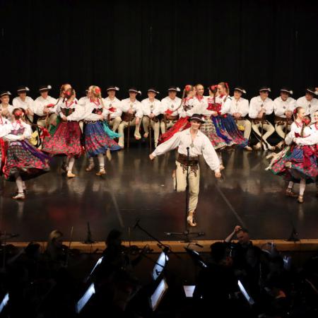Kobiety i mężczyźni z zespołu "Śląsk" tańczą na scenie