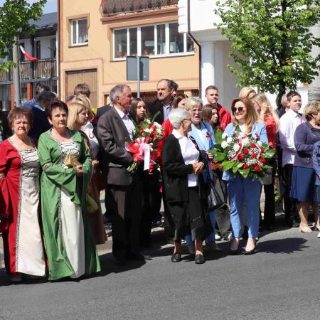 Grupa mieszkańców Drzewicy stoi pod pomnikiem 