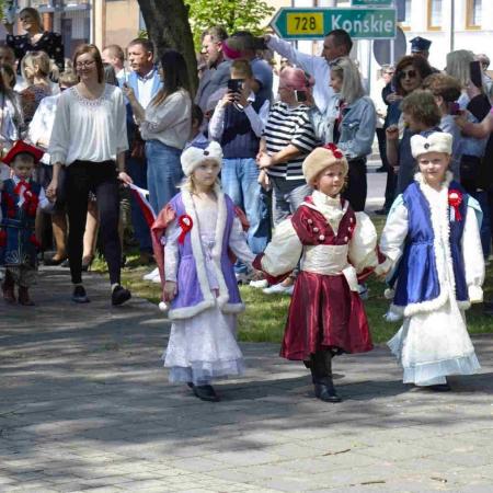 Trójka dzieci pod pomnikiem w strojach 