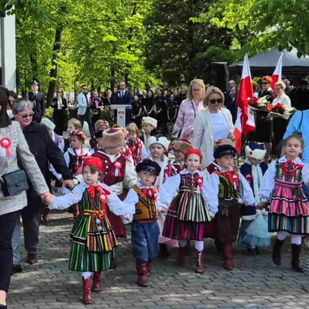 Dzieci w strojach ludowych pod pomnikiem