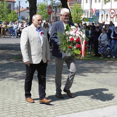 Dwóch mieszkańców Drzewicy niesie wieniec pod pomnik 