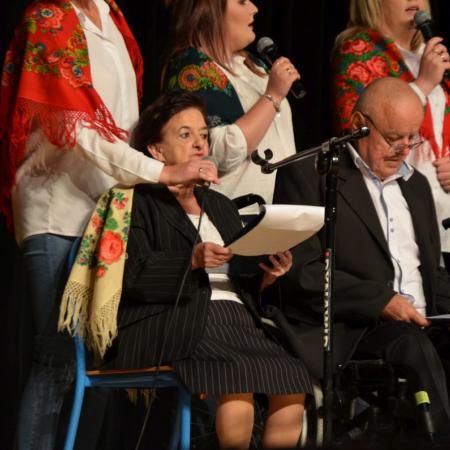 Kobieta na wózku inwalidzkim śpiewa do mikrofonu.