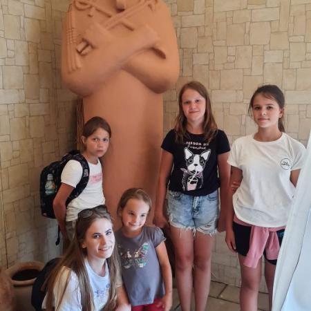 Kobieta z dziemi pozuje przy posągu Faraona