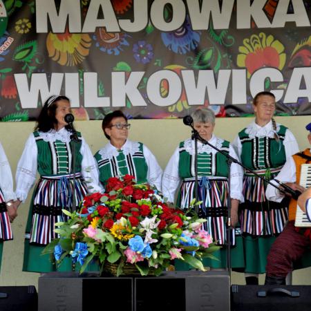Kobiety występują na scenie w Wilkowicach , obok nich mężczyzna gra na akordeonie.