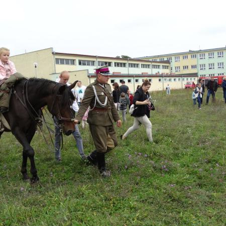Koń prowadzony przez ułana. Na koniu siedzi dziewczynka. Spotkanie integracyjne dla mieszkańców gminy i miasta Drzewica